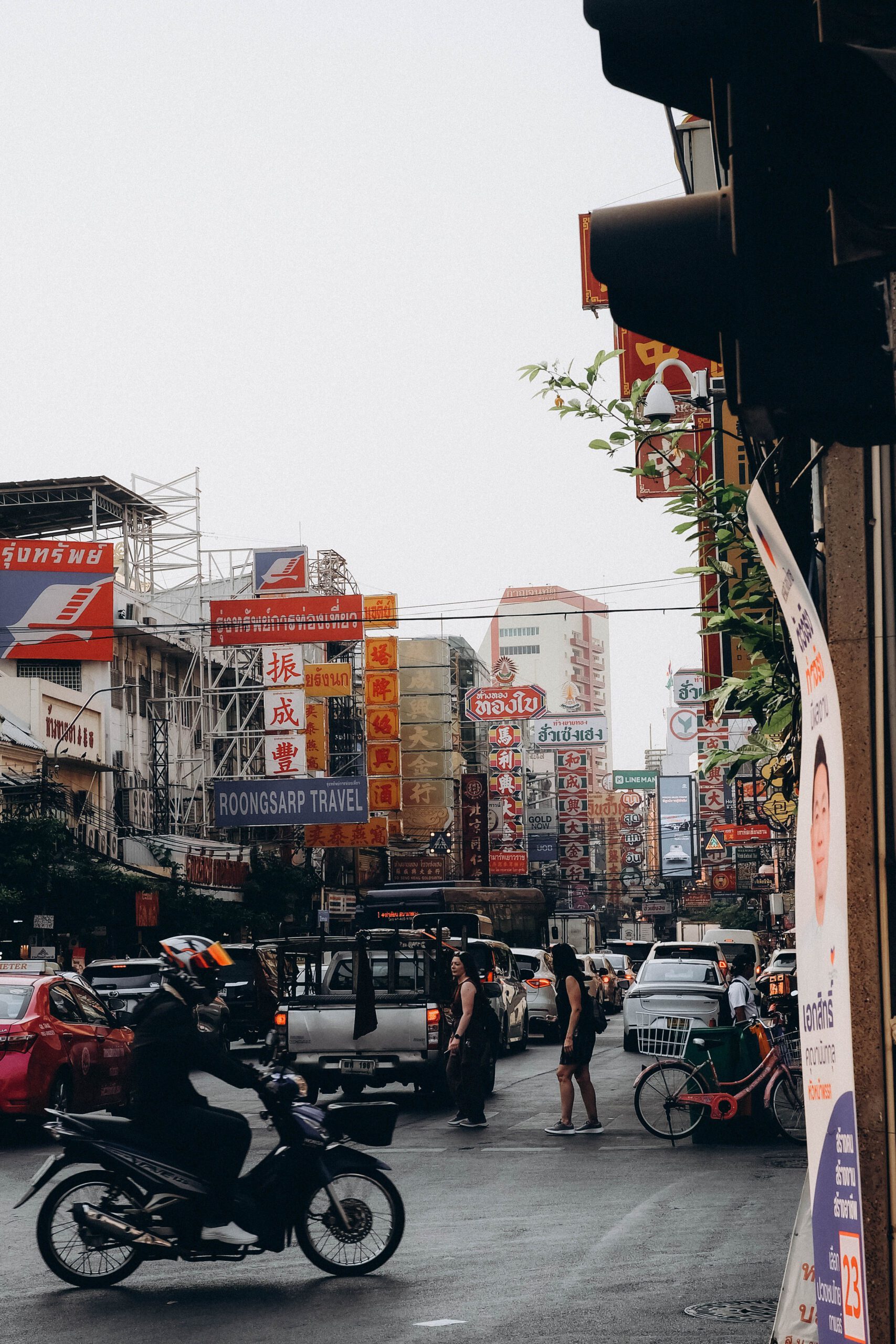 A lively street view of Chinatown in Bangkok, filled with people and vibrant signs.